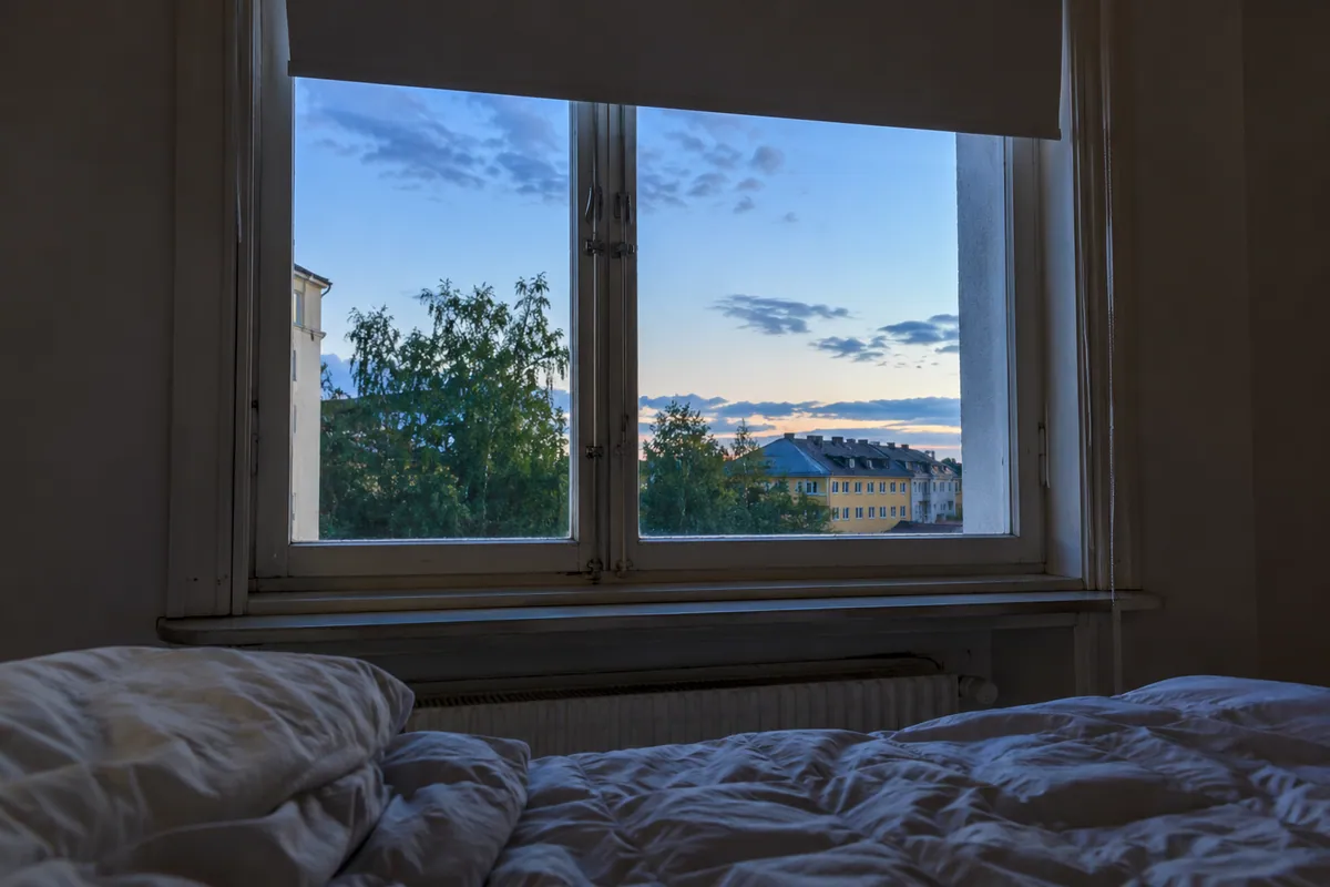 Valoisa kesäyö makuuhuoneen ikkunan takana.